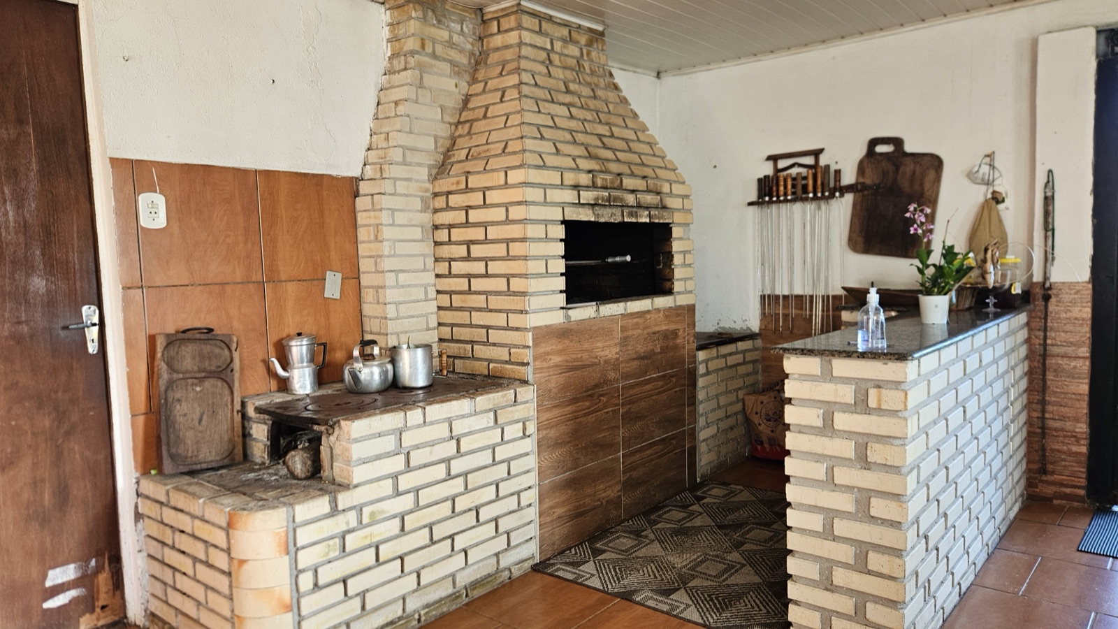 Área gourmet com parrilla e fogão a lenha